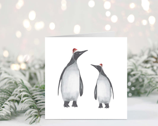 Hand-drawn Christmas card featuring Alya and baby penguin wearing festive red hats