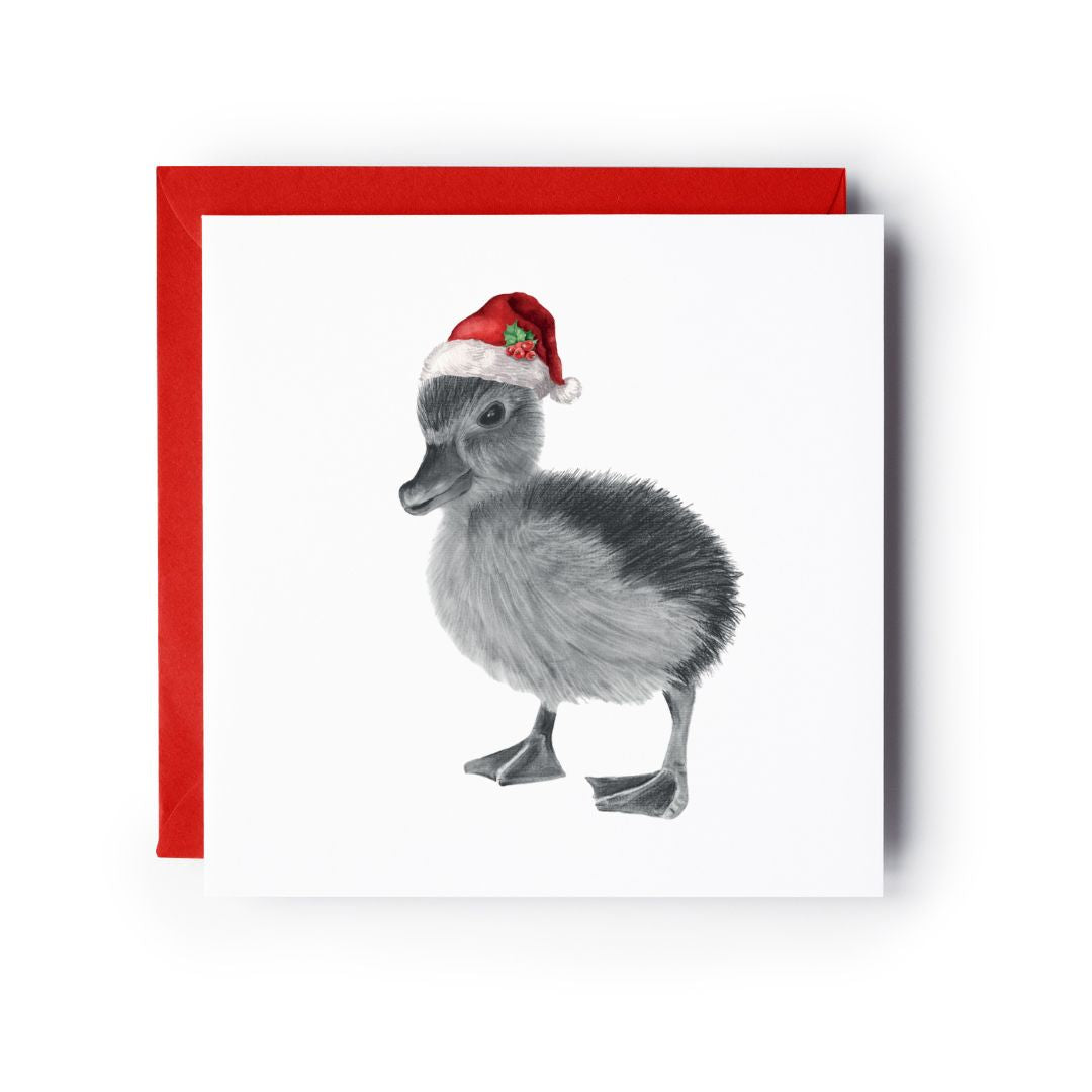 Hand-illustrated Christmas greeting card featuring an adorable duckling wearing a red Santa hat, perfect for sending festive cheer.