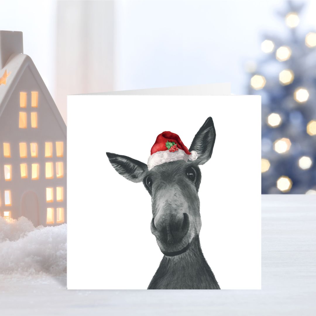 Charming festive card with Sirus the donkey wearing a Santa hat, hand-drawn illustration.