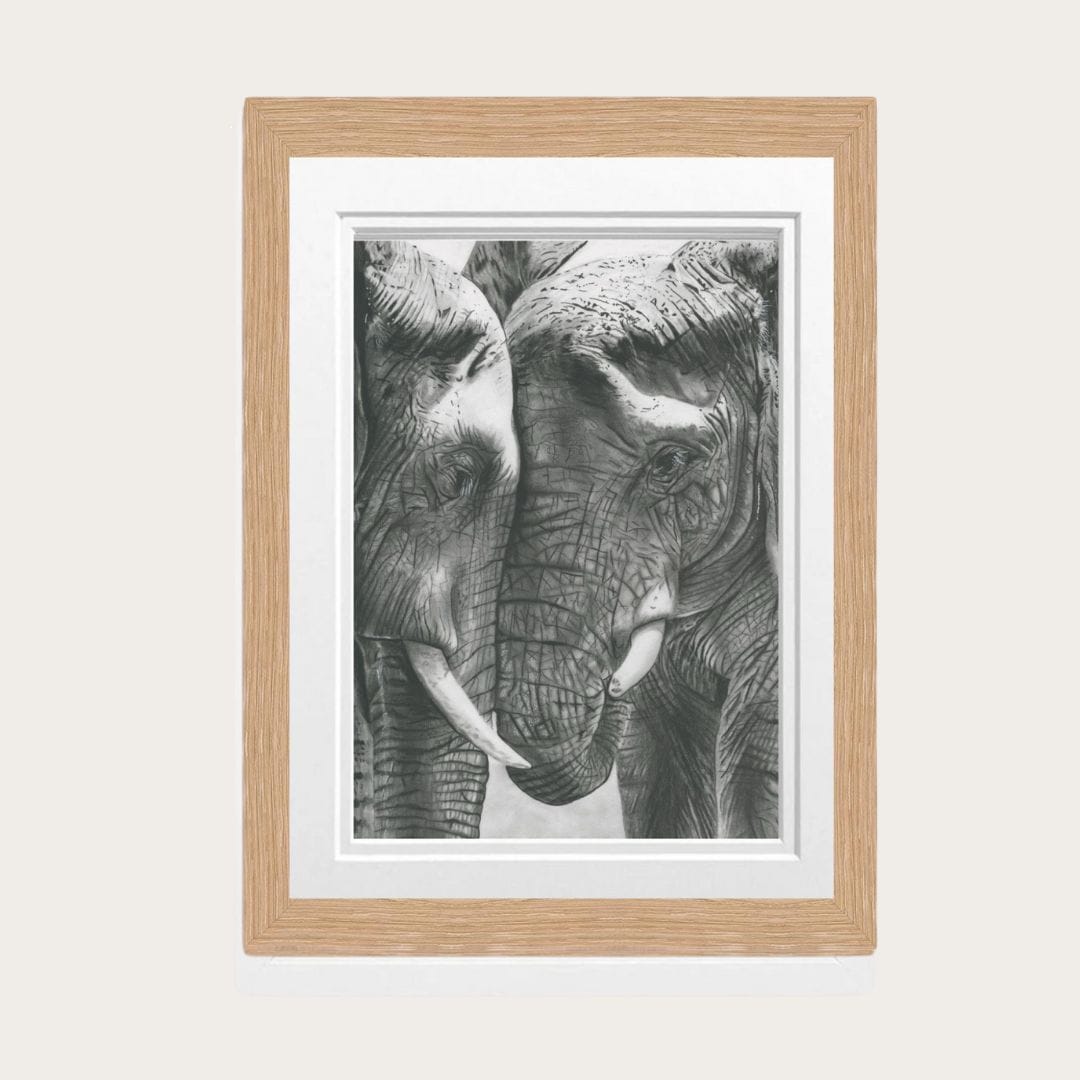 A beautifully detailed hand-drawn fine art print featuring two elephants nuzzling, framed in oak, perfect for adding a touch of nature-inspired elegance to your home decor.