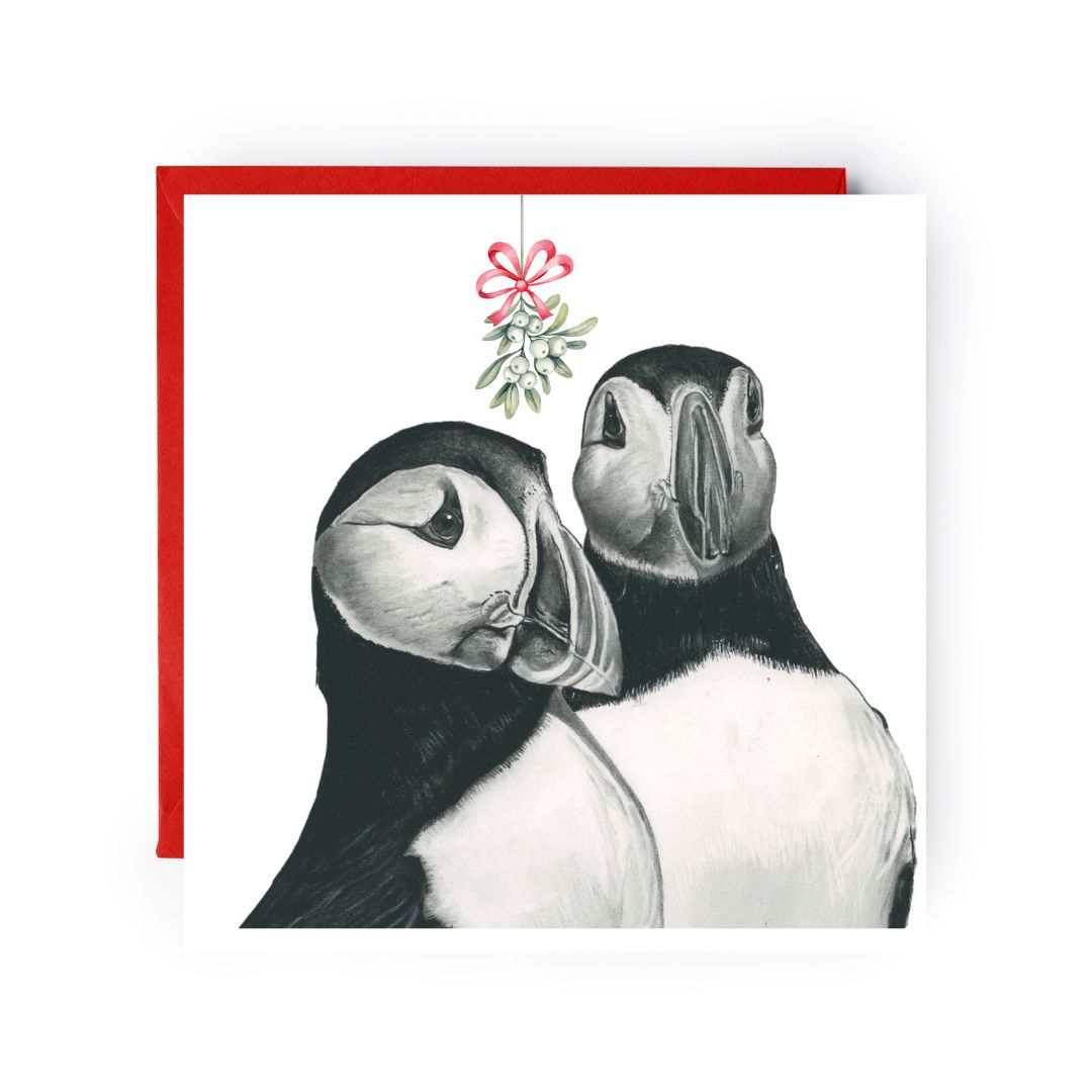Charming puffins sharing a sweet kiss under the mistletoe, perfect for holiday wishes on Christmas