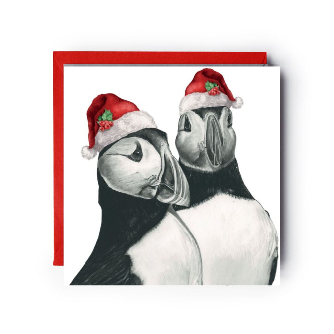 Festive Christmas card featuring Gemini the puffin couple in red Santa hats.