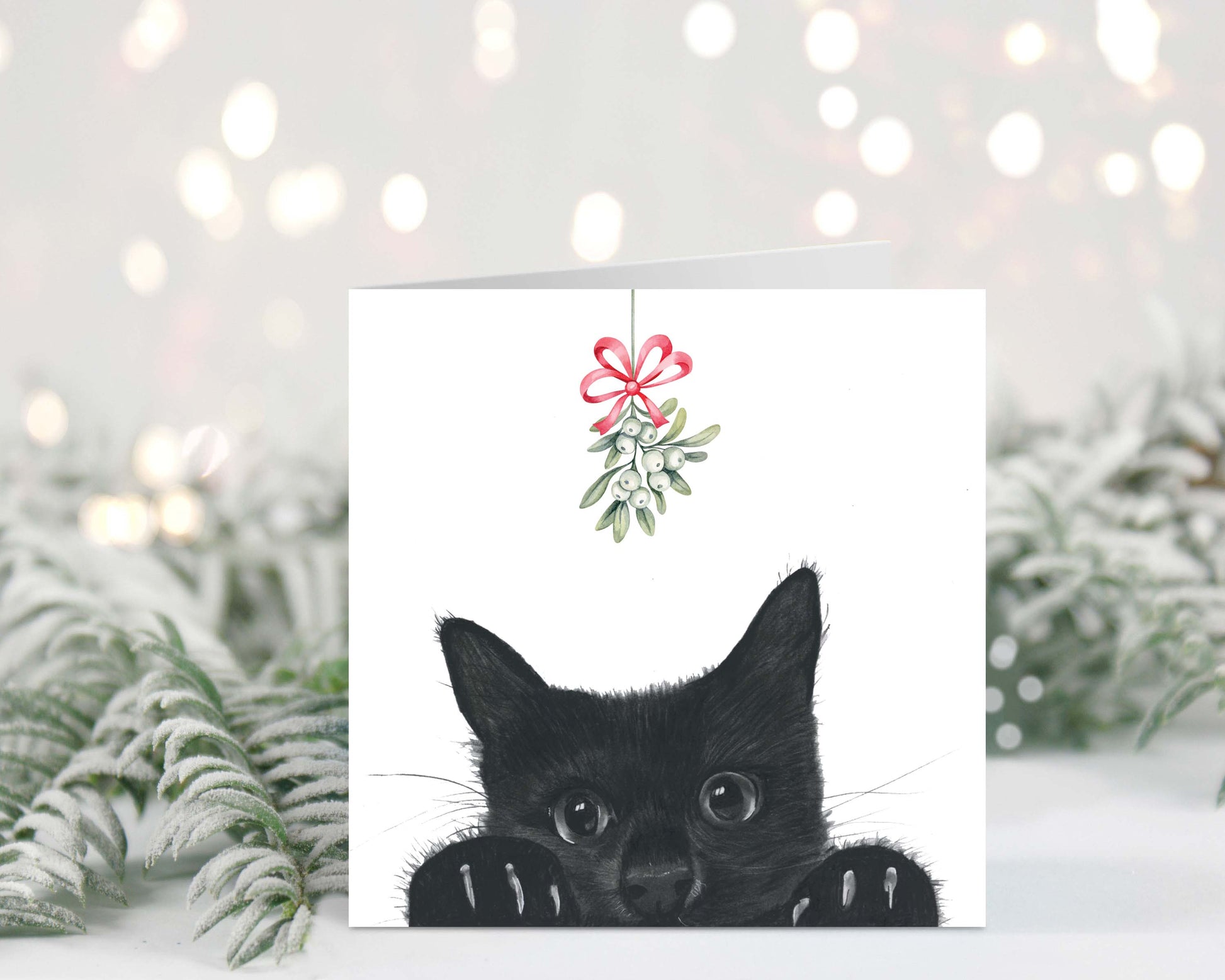 Adorable kitten named Sansuna under the mistletoe on a festive Christmas card.
