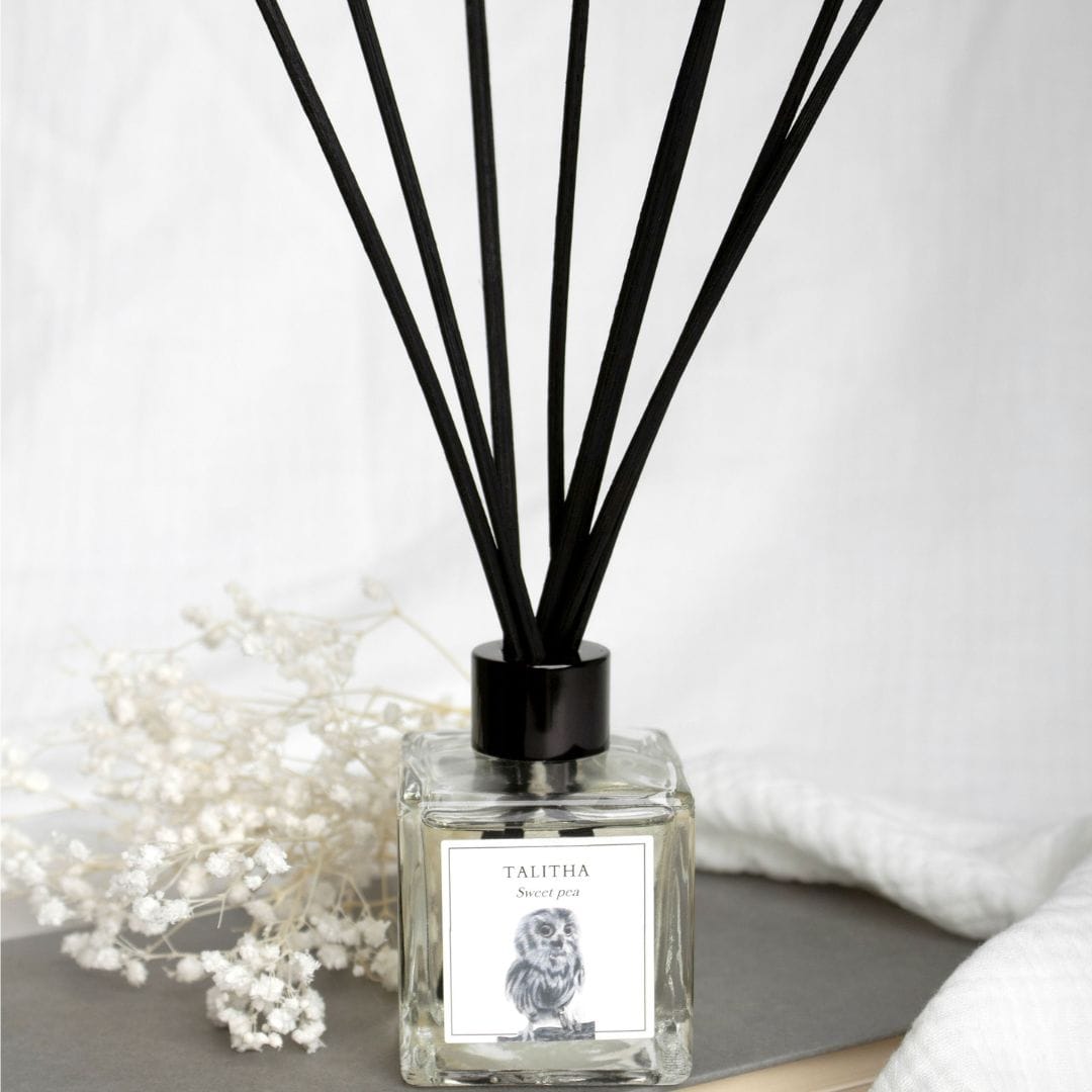 A Sweet Pea Luxury Reed Diffuser in a stylish glass bottle with natural reeds, gently diffusing a floral and calming sweet pea fragrance to elevate the atmosphere of any room