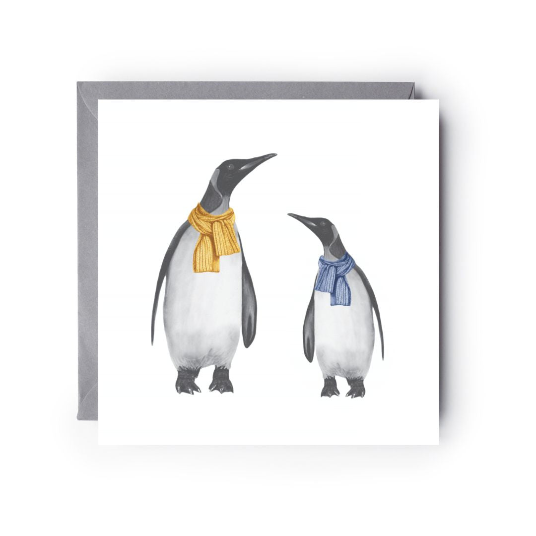 Hand-drawn winter greeting card showing a penguin and baby wrapped warmly in scarves.