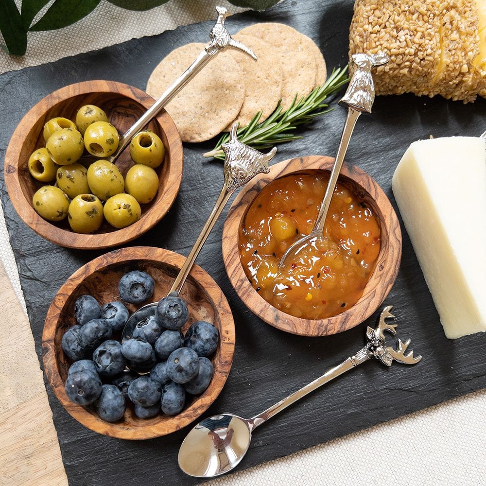 A set of 4 Country Animals teaspoons, each featuring a different animal design on the handle, placed beside a selection of chutneys and olives on a rustic serving board. The spoons are elegantly used to serve the chutneys, adding a charming, countryside touch to the spread with their detailed animal motifs.