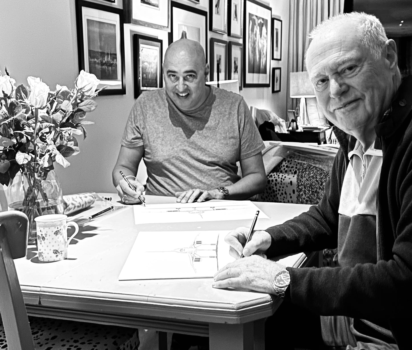 A photograph capturing the moment when Jock Lowe, Concorde pilot and artist, and Captain of Concorde, sign limited edition Concorde prints. The image showcases the intimate and special occasion, with both Jock Lowe and the Captain personalizing the artwork, adding authenticity and a personal touch to each print. This image underscores the rare and significant connection between the iconic Concorde aircraft and the talented individuals who flew it.