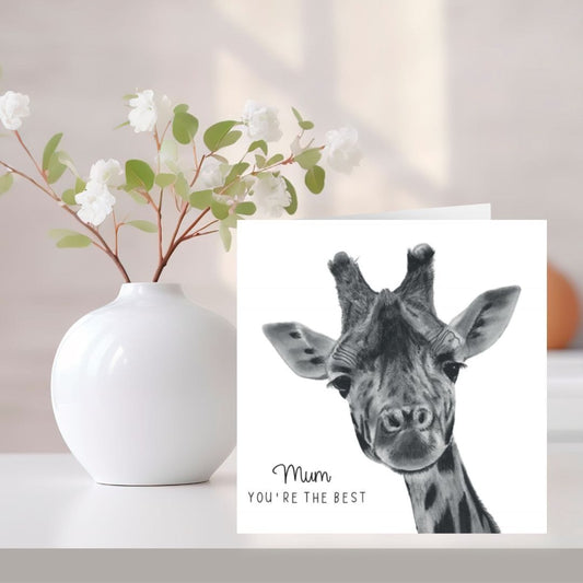 A lovingly hand-drawn "Mum, You're the Best" giraffe greeting card, printed on Libra Fine Arts cardstock for a high-quality finish. The card stands upright, displaying its adorable giraffe illustration. Ideal for Mother's Day, birthdays, thank you notes, or just because. Blank inside, ready for a personal message.