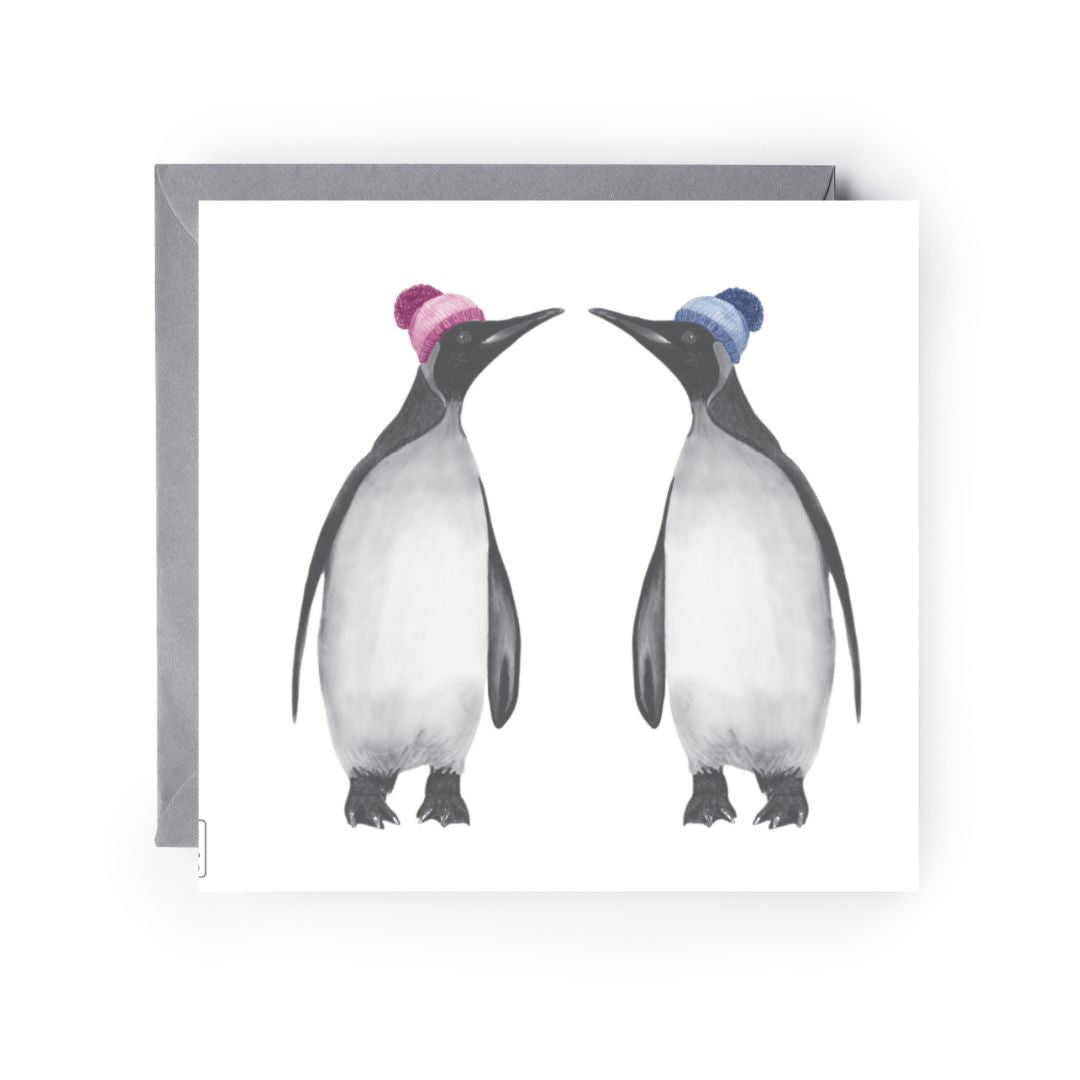 Hand-drawn winter greeting card of a penguin couple wearing cosy bobble hats.

