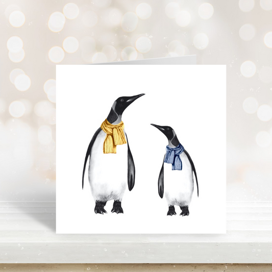 Cute illustration of a penguin and baby bundled up in scarves on a festive card.

