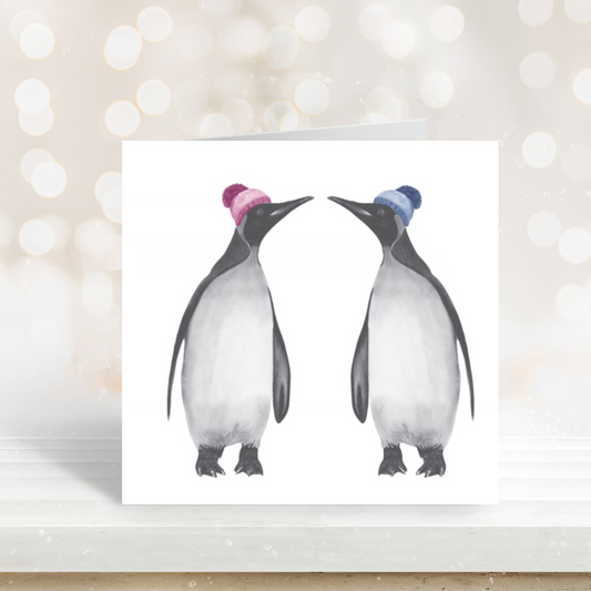 Cute illustration of two penguins bundled up in bobble hats on a seasonal card.

