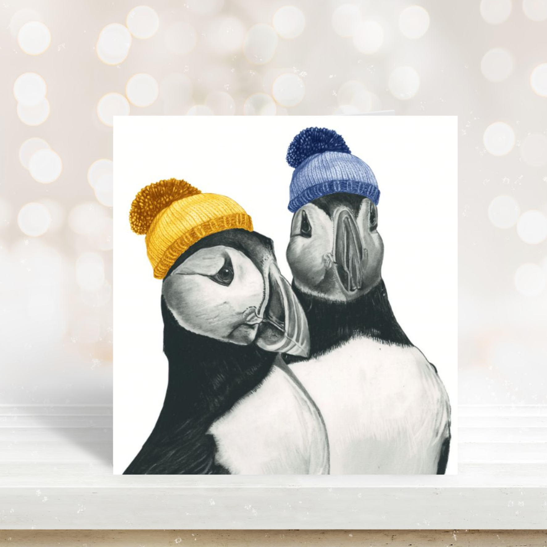 Cute illustration of two puffins on a festive winter greeting card.

