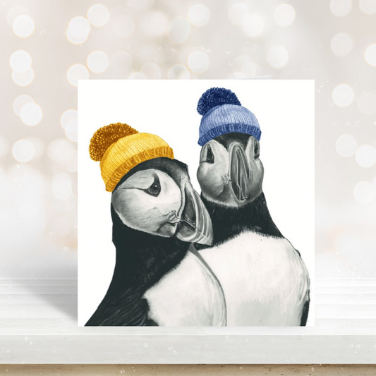 Cute illustration of two puffins on a festive winter greeting card.


