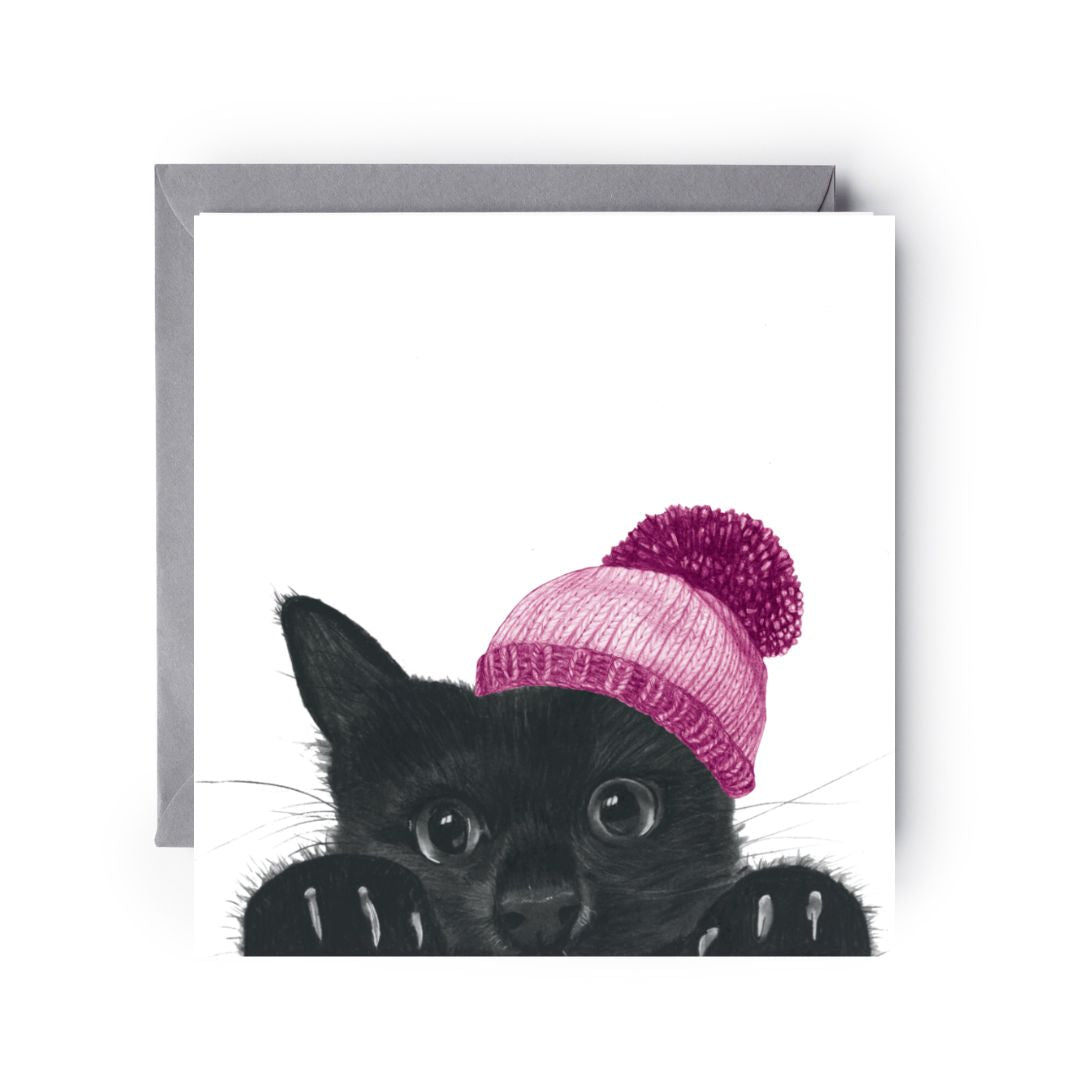 Winter Wishes card showing an adorable cat in a pink bobble hat peeking playfully from the corner