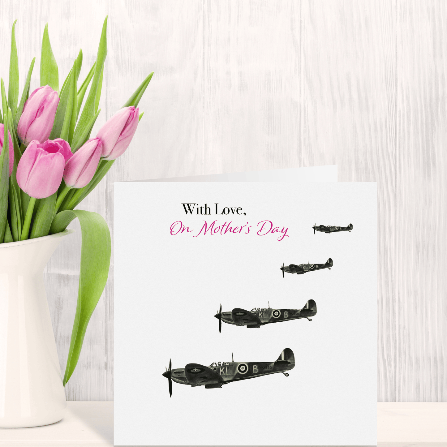 Greeting card with vintage airplane illustrations and 'With Love, On Mother's Day' text next to a vase of pink tulips.