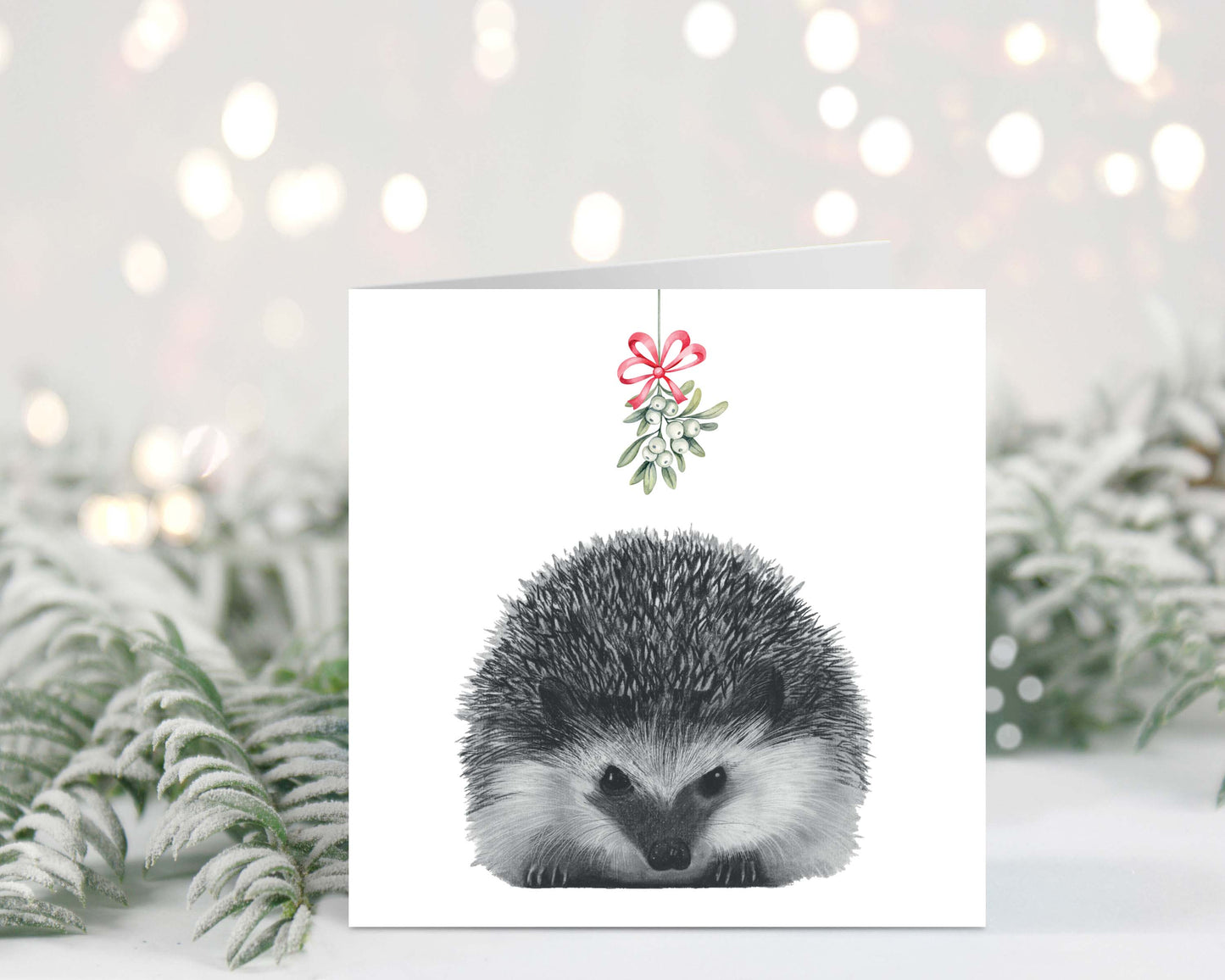 Cute hand-drawn hedgehog holding mistletoe on a festive Christmas greeting card.