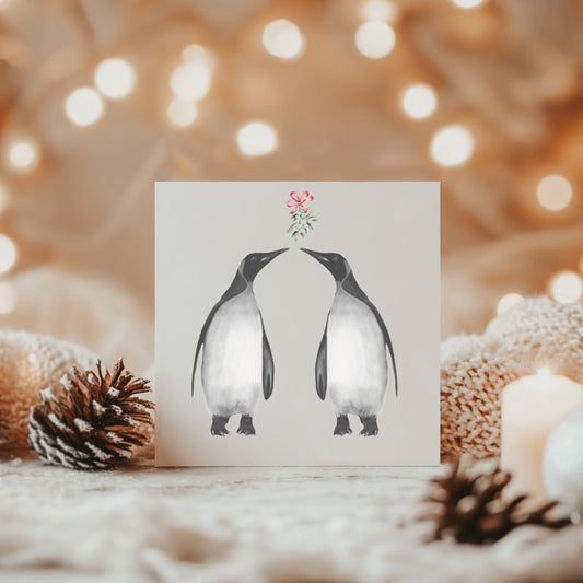 A charming holiday greeting card with a cute penguin couple under the mistletoe, beautifully hand-illustrated to bring warmth and joy to your loved ones this Christmas