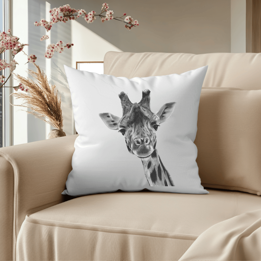 White pillow with a giraffe design on a beige couch