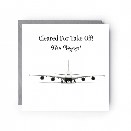 Greeting card with airplane illustration and text 'Cleared For Take Off! Bon Voyage!' on a white background