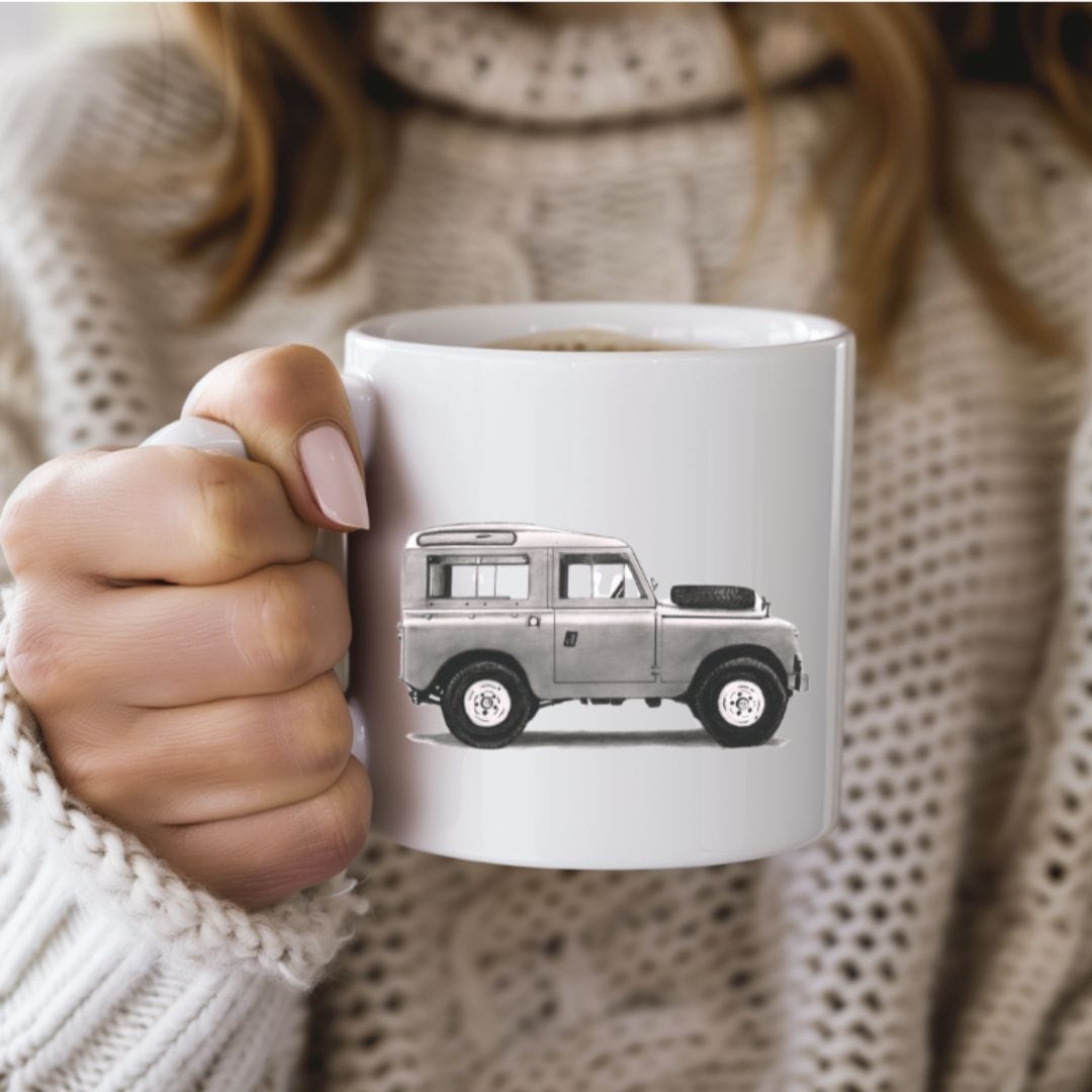 This premium Land Rover Bone China Mug features a detailed illustration of the iconic Land Rover, making it the perfect gift for car enthusiasts and Land Rover fans. Crafted from fine bone china, this mug combines style, functionality, and a love for classic vehicles, perfect for your morning coffee or tea.