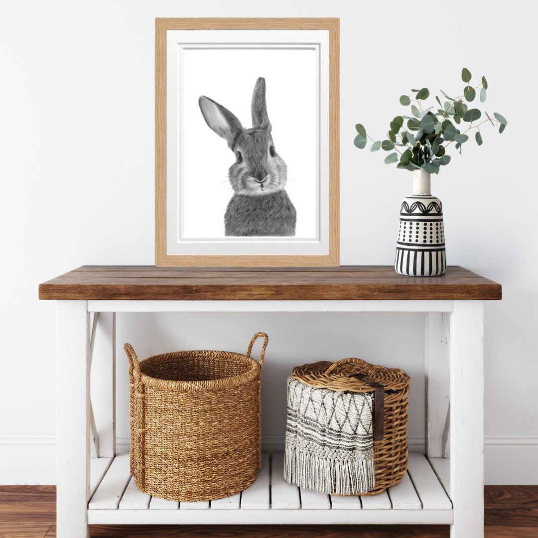 Bellatrix the Bunny Fine Art Print placed on a wooden side table, highlighting the delicate linework and countryside charm of this hand-drawn illustration