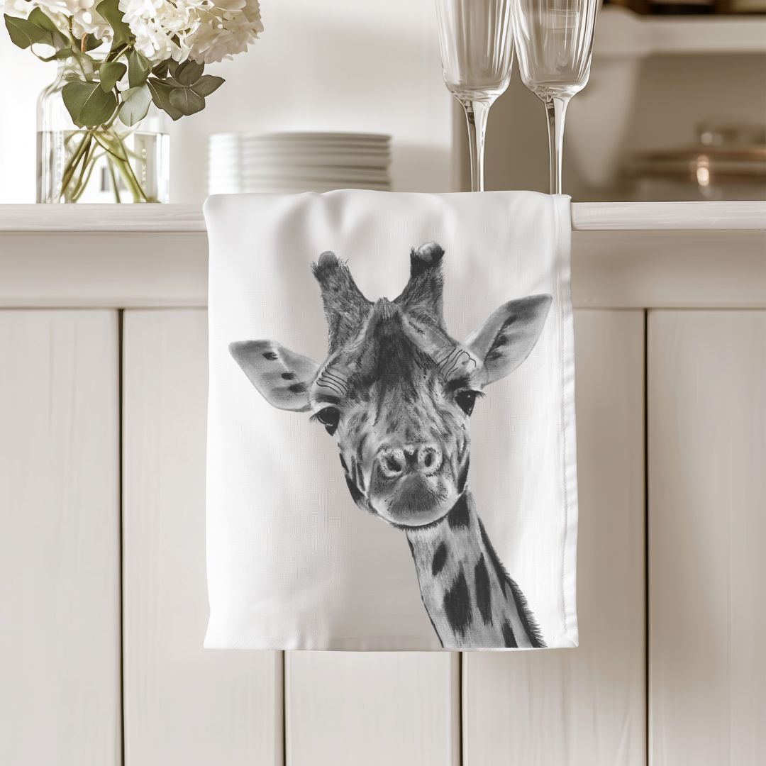 Cotton tea towel featuring Maya the Giraffe, a delightful and elegant design to brighten up your kitchen. A perfect gift for giraffe lovers and animal-themed home decor.