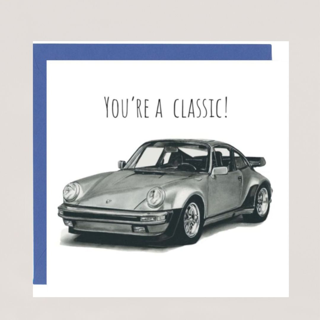 A hand-drawn "You're a Classic" Porsche greeting card displayed with a blue envelope. Perfect for car enthusiasts and classic car lovers. Printed on Libra Fine Arts FSC-certified cardstock, offering a high-quality, sustainable choice. Blank inside for a personal message.







