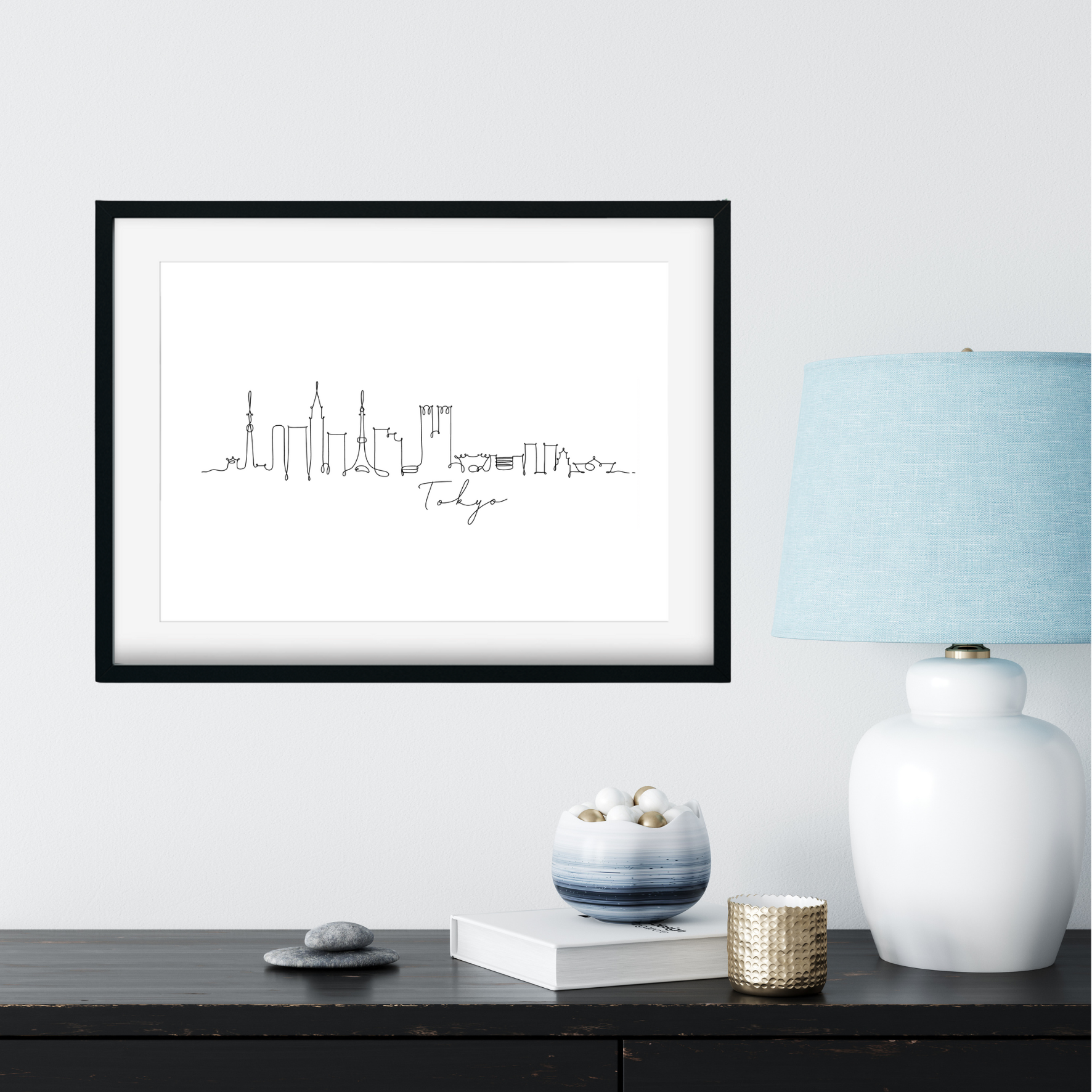 Framed city skyline print on a wall above a desk with decorative items.